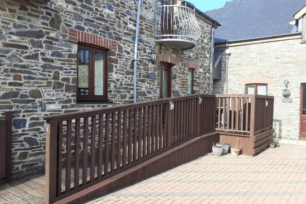 une terrasse en bois devant une maison en pierre dans l'établissement The Stable, à Aberystwyth