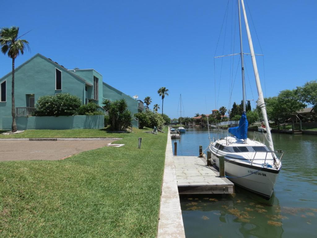 a sailboat docked at a dock next to a house at Multi Resorts at Puente Vista in Corpus Christi