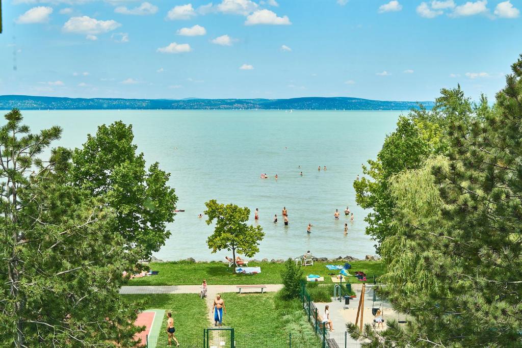 a group of people in the water at a beach at Cadet Apartments - hostAID in Siófok
