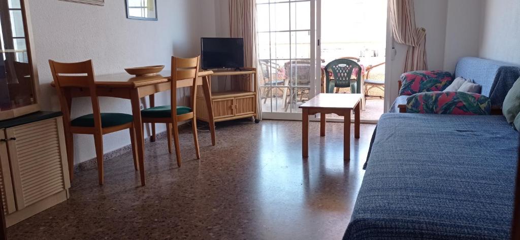 a living room with a couch and a table and a tv at Apartamento Jardin II in Gandía