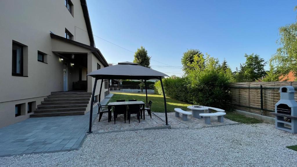 a patio with a table and benches and an umbrella at CITY Apartman in Balatonföldvár