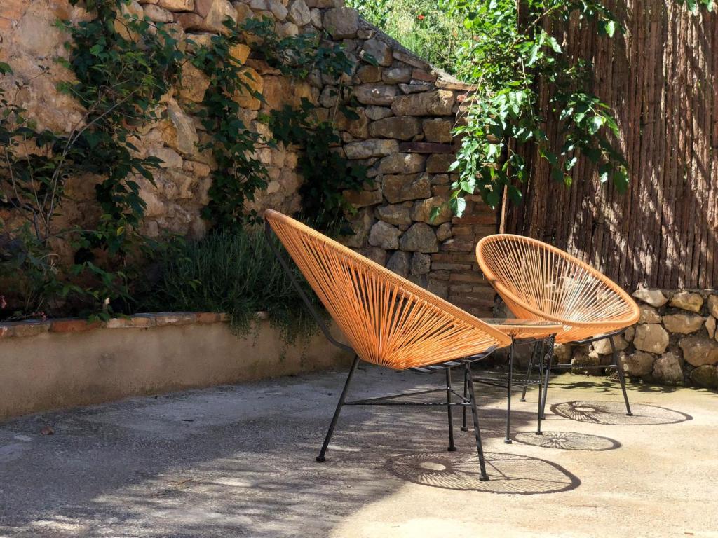 twee stoelen voor een stenen muur bij Apartamento Bajo Los Arcos in Teruel