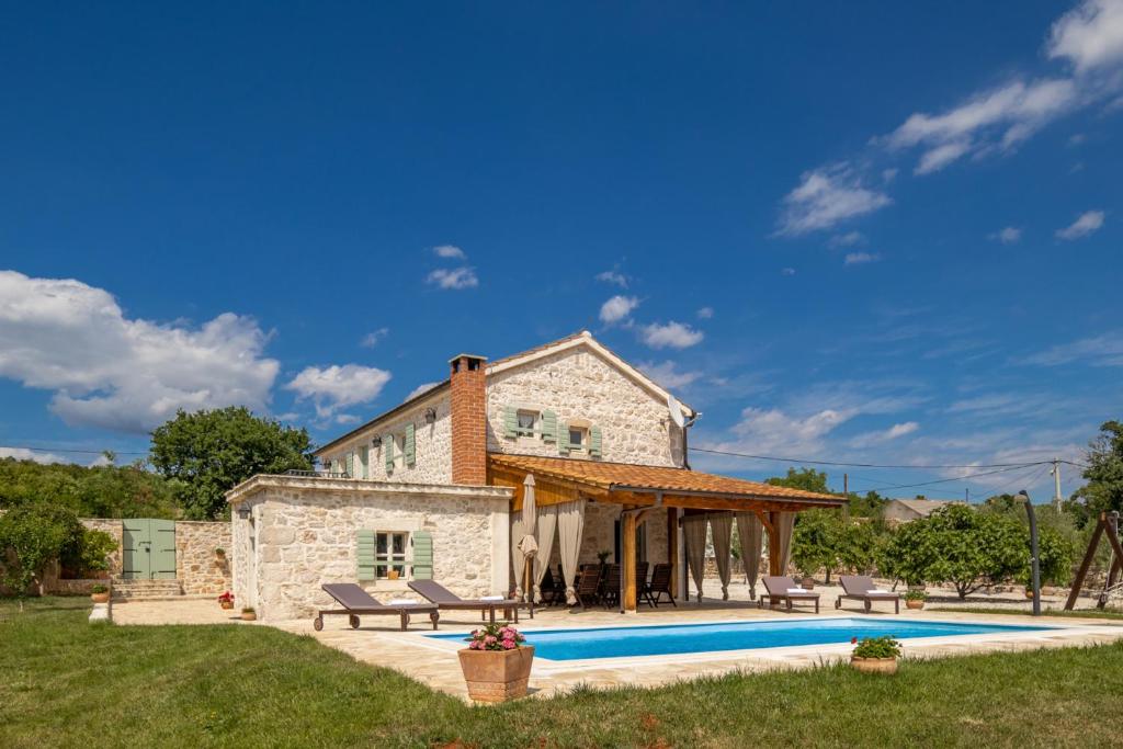 an external view of a stone house with a swimming pool at Villa Jerolim in Slivnica