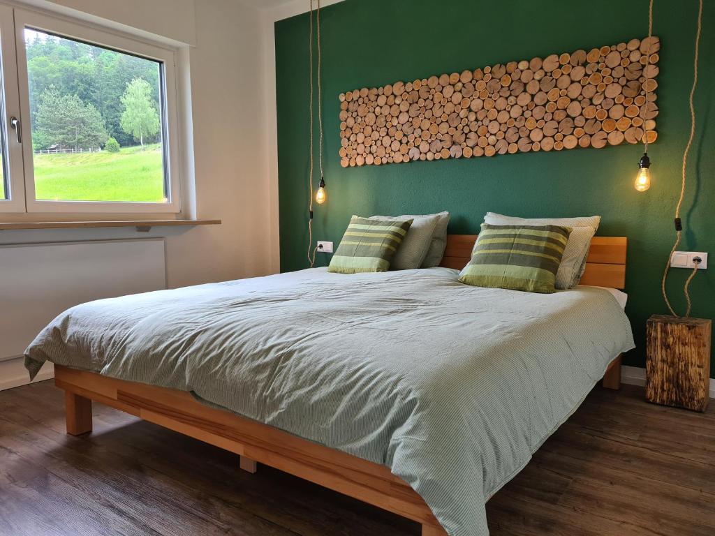 - une chambre avec un grand lit et un mur vert dans l'établissement sünnala, à Batschuns