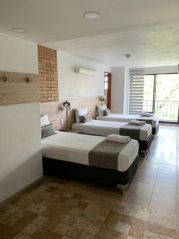Postel nebo postele na pokoji v ubytování Hotel Cabo de la Vela Medellin