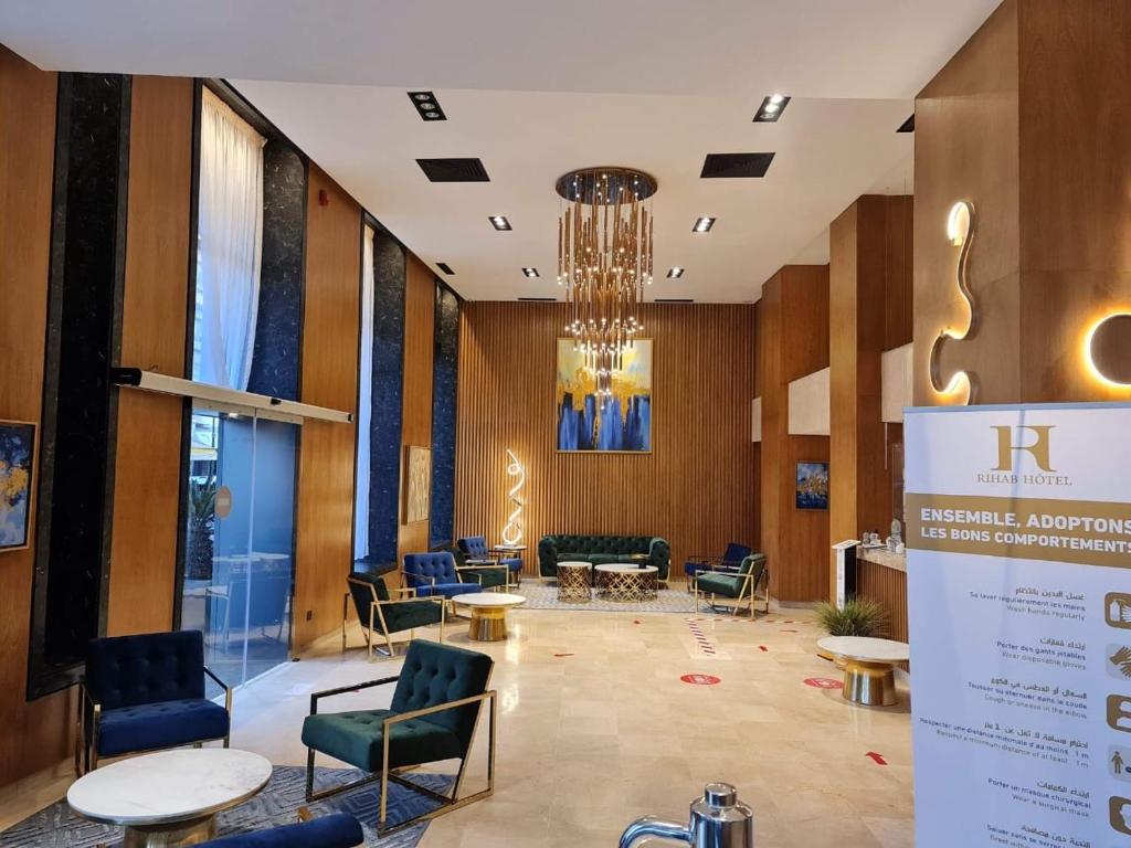a lobby with chairs and tables and a chandelier at Rihab Hotel in Rabat