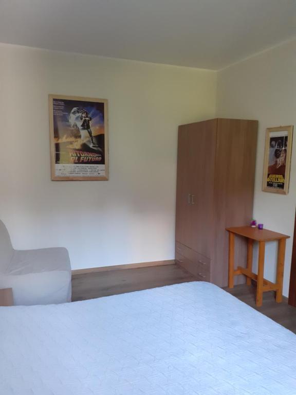 MulazzoにあるCIAK Affittacamereの白いベッドと木製キャビネット付きのベッドルーム1室が備わります。
