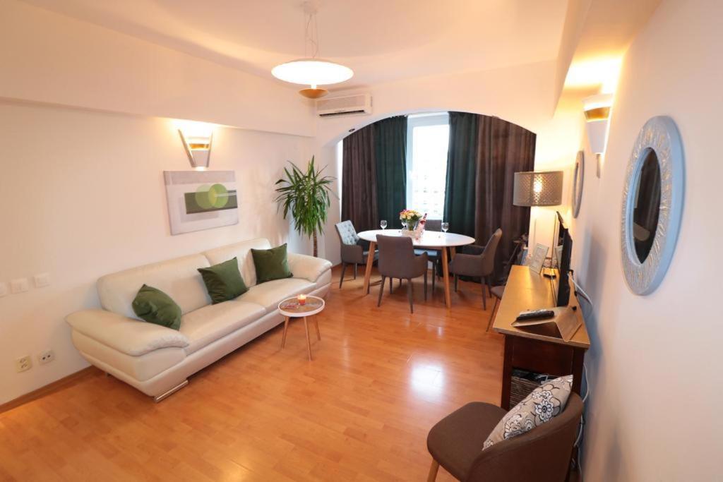 ein Wohnzimmer mit einem Sofa und einem Tisch in der Unterkunft Eva Twin Apartments in Bukarest