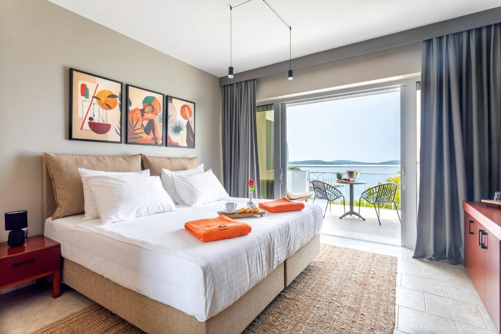 a bedroom with a large bed and a balcony at Hotel Podstine in Hvar