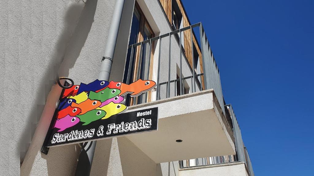 um sinal pendurado do lado de um edifício em Sardines and Friends Hostel 06 na Póvoa do Varzim
