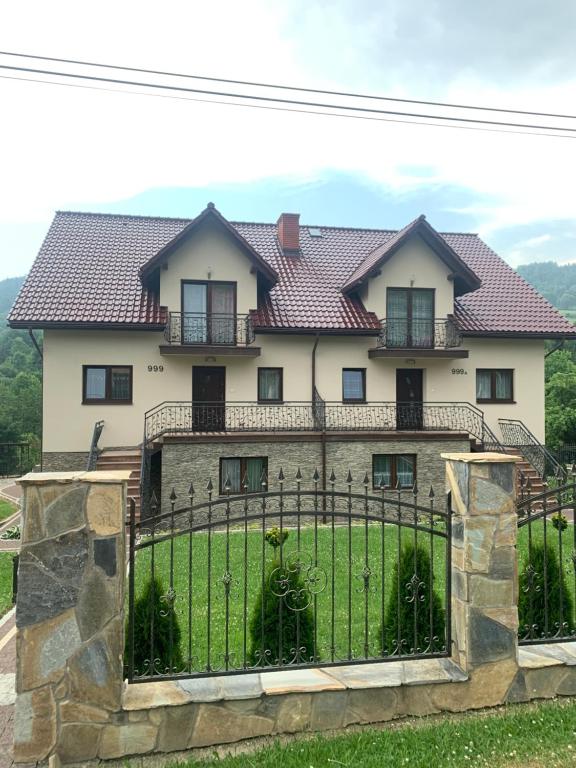 a large white house with a black fence at Villa Wiki w Górach in Kamesznica