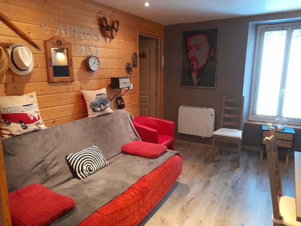 uma sala de estar com uma cama e um sofá vermelho em Le saquet em Ax-les-Thermes