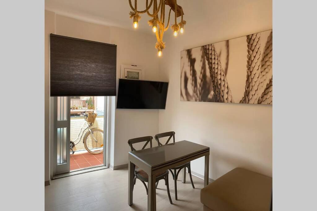 a dining room with a table and a television at 3 MINUTI A PIEDI DAL MARE parking & wifi included FIUMARETTA , in Fiumaretta di Ameglia