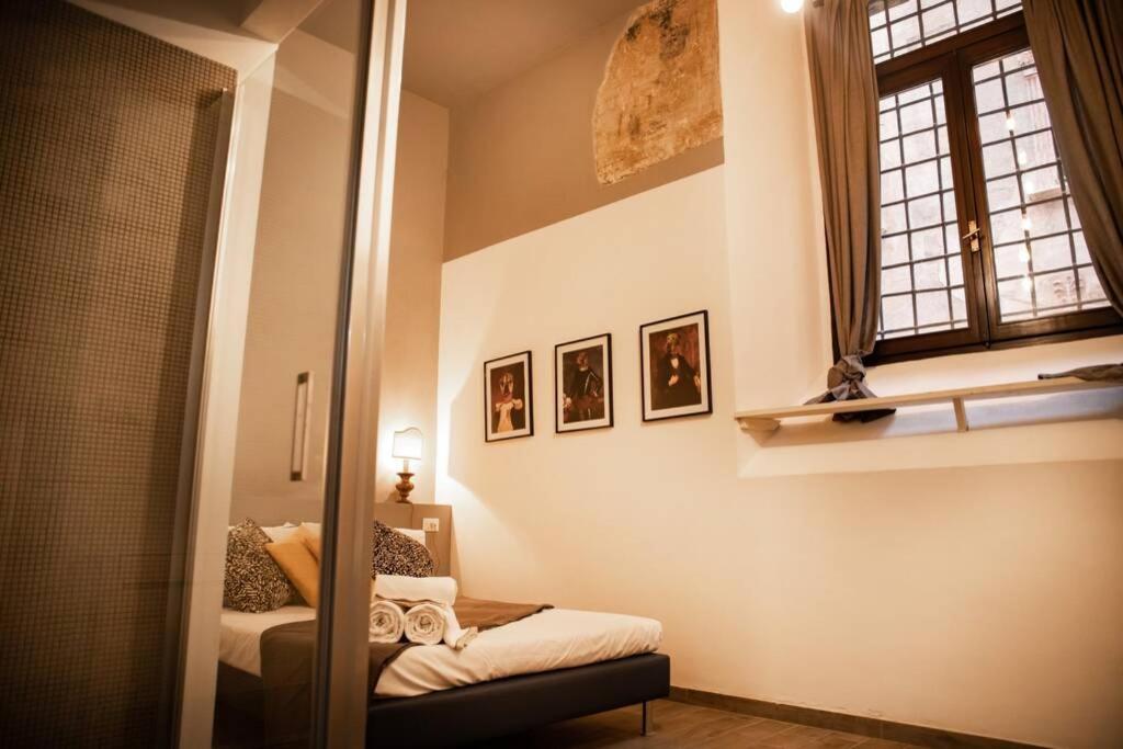 einen Spiegel in einem Zimmer mit einem Bett und einem Fenster in der Unterkunft Relais San Mamaso-Centro Storico in Verona
