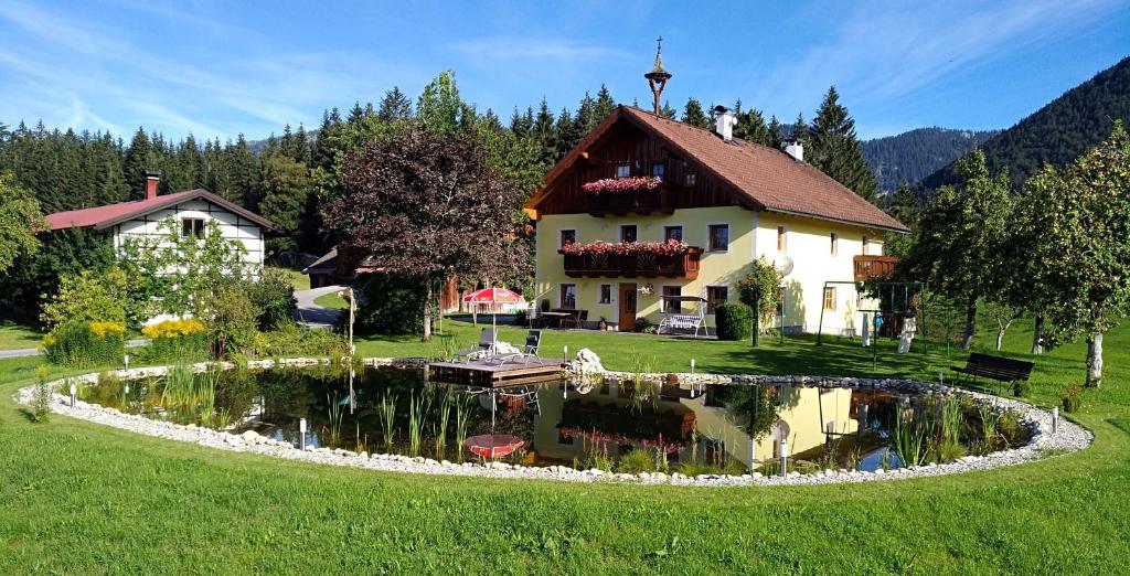 una casa y un estanque frente a una casa en Spulhof en Abtenau
