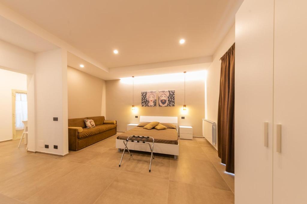 a bedroom with a bed and a couch at I Mori Apartments in Cefalù