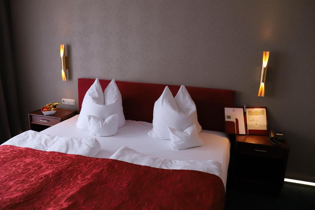 a hotel room with a red and white bed with pillows at Panoramahotel &amp; Restaurant am Marienturm in Rudolstadt