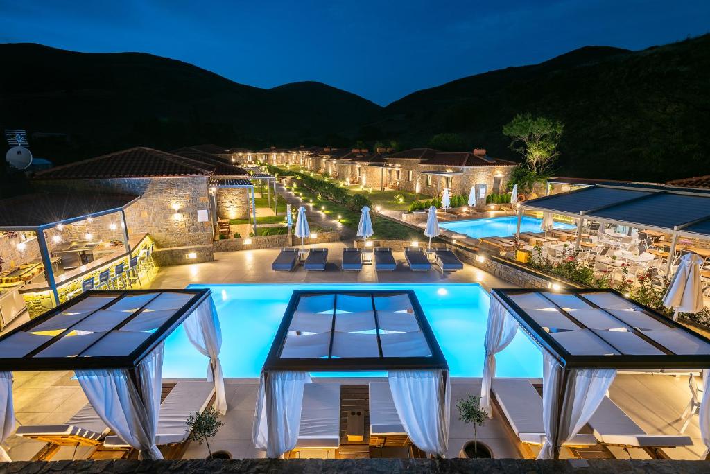 a view of a swimming pool at night at Αngelikon Luxurious Apartments in Agios Ioannis Kaspaka