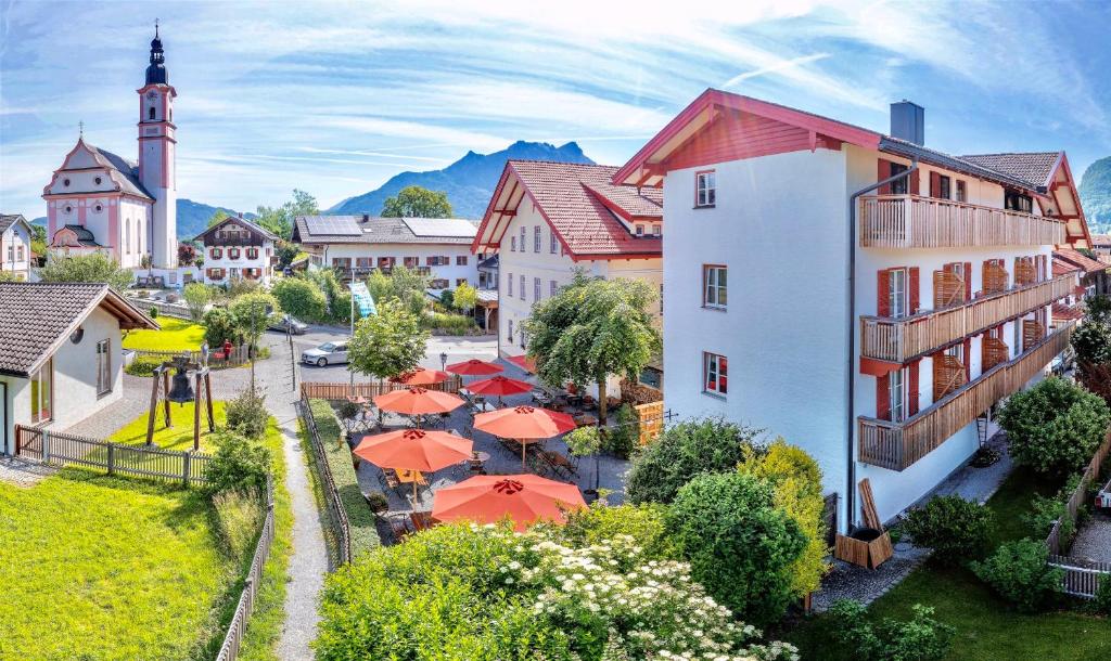 een klein stadje met oranje paraplu's en een kerk bij Gasthof-Hotel Dannerwirt in Flintsbach