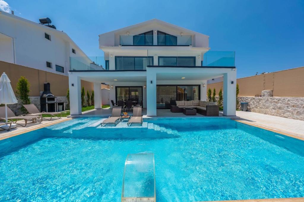 a swimming pool in front of a house at La Marbella Villa in Fethiye
