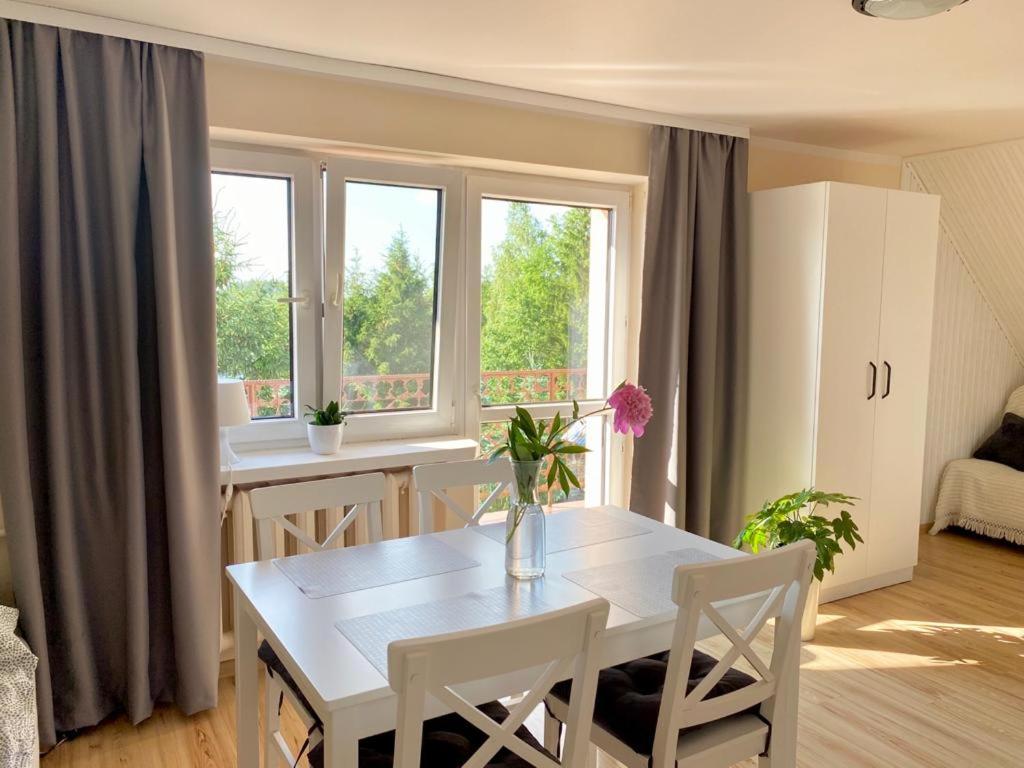 ein Wohnzimmer mit einem weißen Tisch und Stühlen in der Unterkunft Apartament Gościnny Zakątek in Sumowo