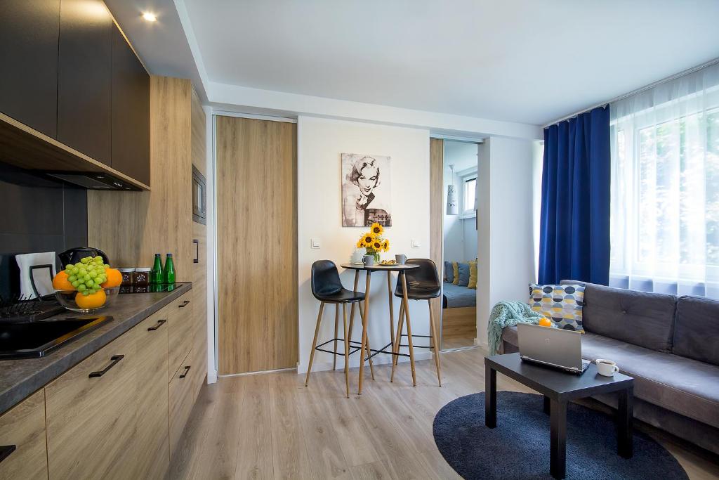 cocina y sala de estar con sofá y mesa en W&K Apartments - Compact I en Koszalin