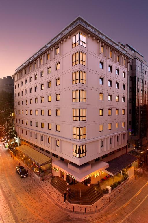 duży biały budynek przy ulicy miejskiej w obiekcie Nippon Hotel w Stambule