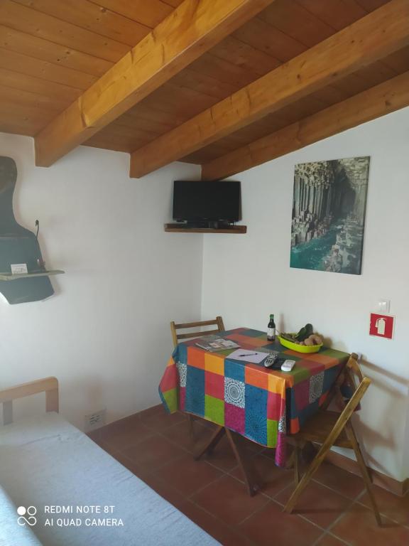Habitación con mesa, cama y guitarra en Coureladaltura, en Aljezur