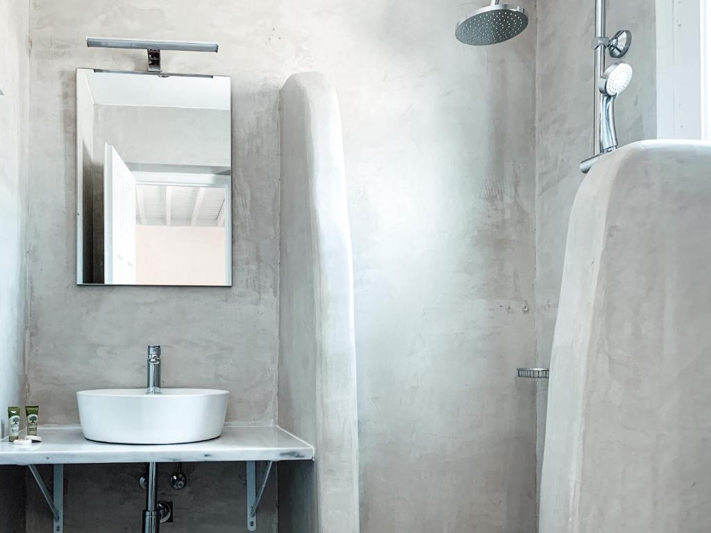 a bathroom with a sink and a mirror at Fabrica Sunset Apartments in Megali Ammos