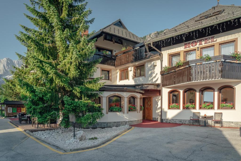 a hotel with a tree in front of it at Garni Hotel Miklič in Kranjska Gora