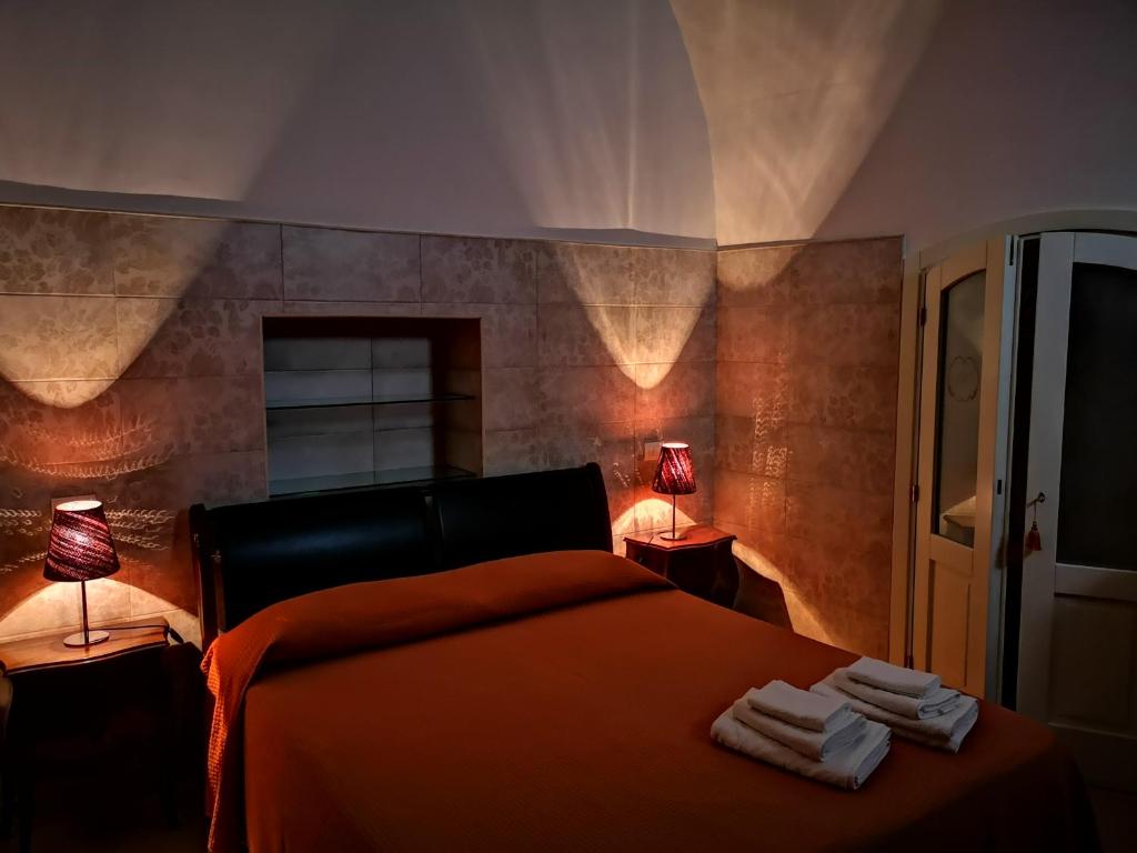 ガリポリにあるB&B Corti Carmelaのベッドルーム1室(ランプ2つ、タオル付)