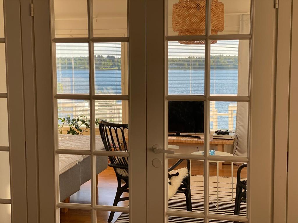 a room with two windows and a desk with a television at Ilmola resort by the river in Keminmaa