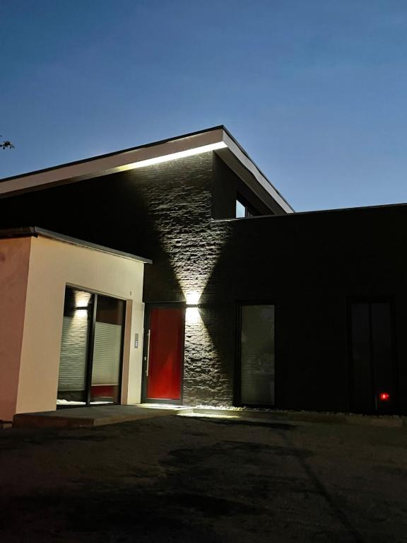 a black and white house with a red door at Ferienwohnung Strandkieker 2 in Ueckermünde
