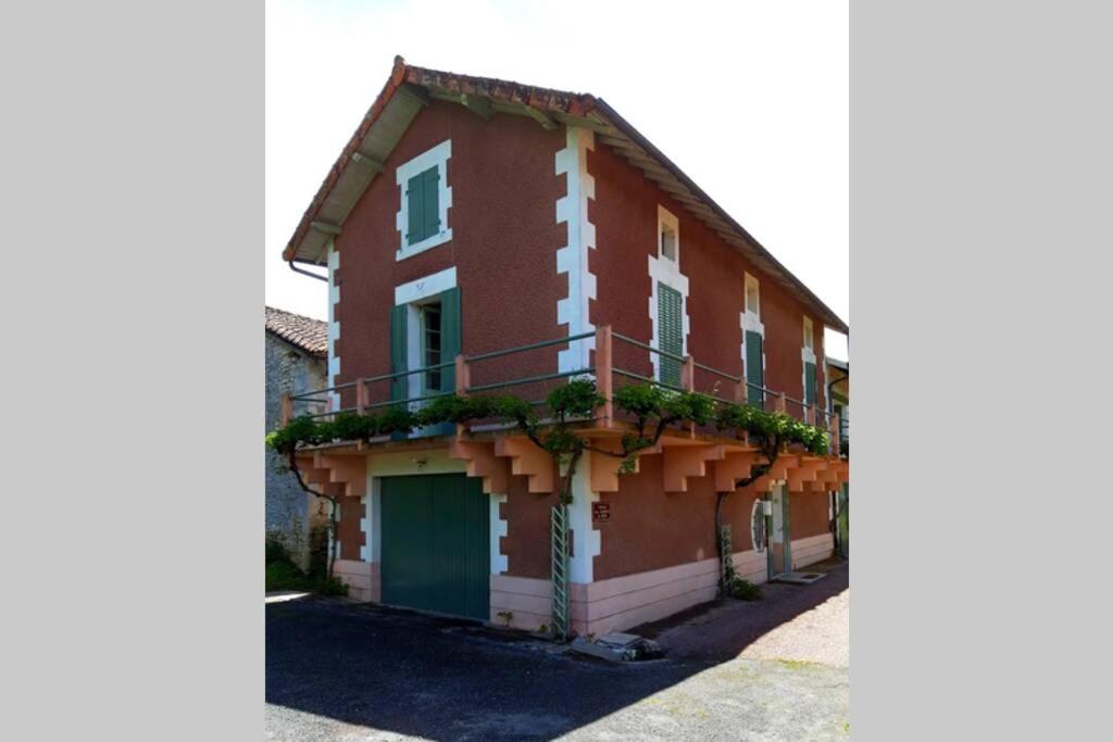 a red and white building with a balcony at Maison de location saisonnière en Périgord Vert in Saint-Front-la-Rivière