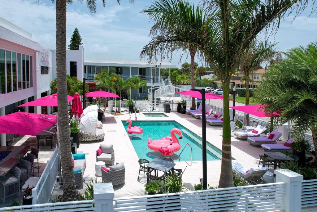 a patio area with umbrellas, chairs, and tables at The Saint Hotel in St Pete Beach