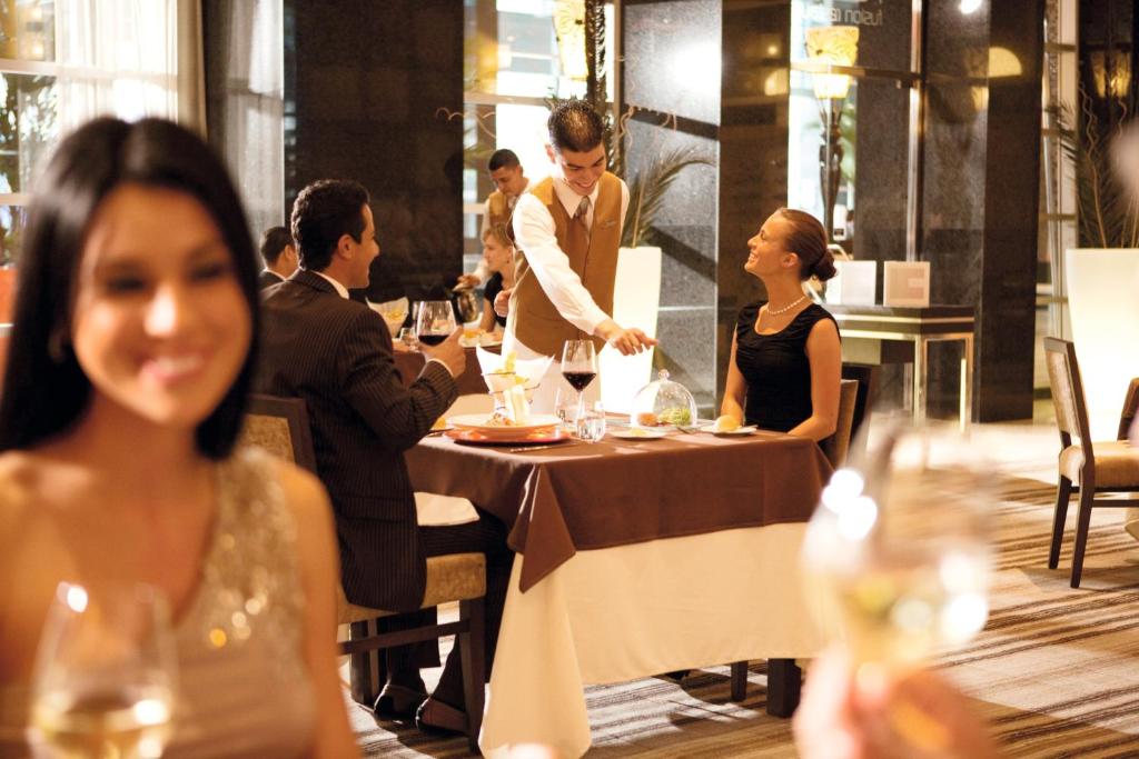 a group of people sitting at a table in a restaurant at Riu Plaza Panamá in Panama City