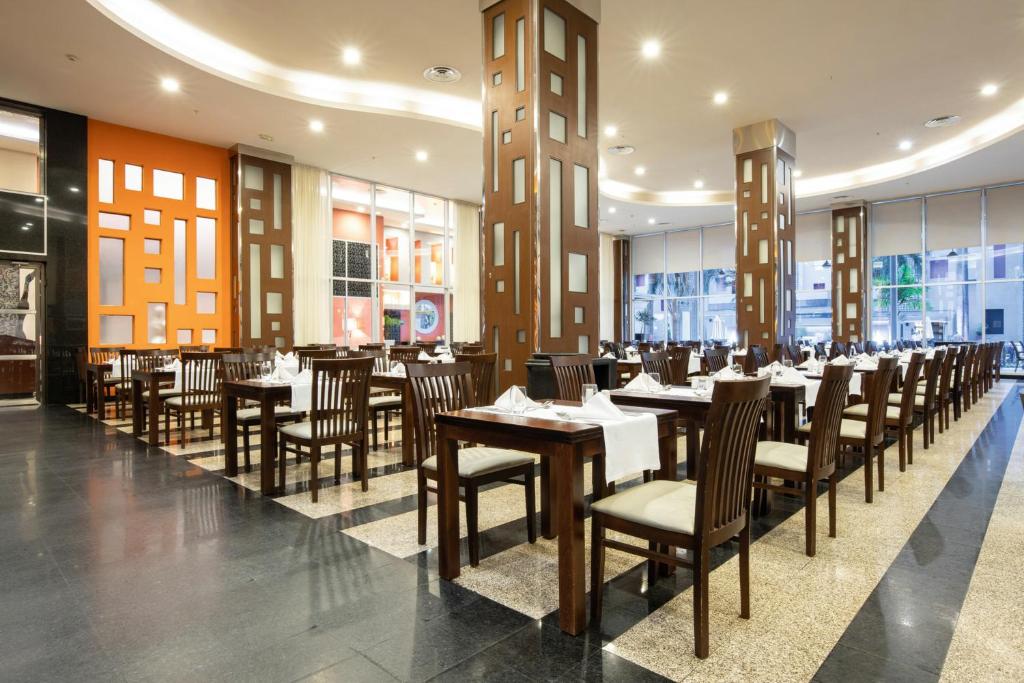 a dining room with tables and chairs in a restaurant at Riu Plaza Panamá in Panama City
