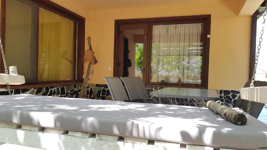 Habitación con cama, mesa y sillas. en Casa la Petcu, en Costinesti