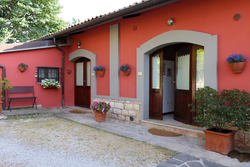 una casa rossa con una panchina davanti di IL TURRIONE "app. Santa Chiara" ad Assisi