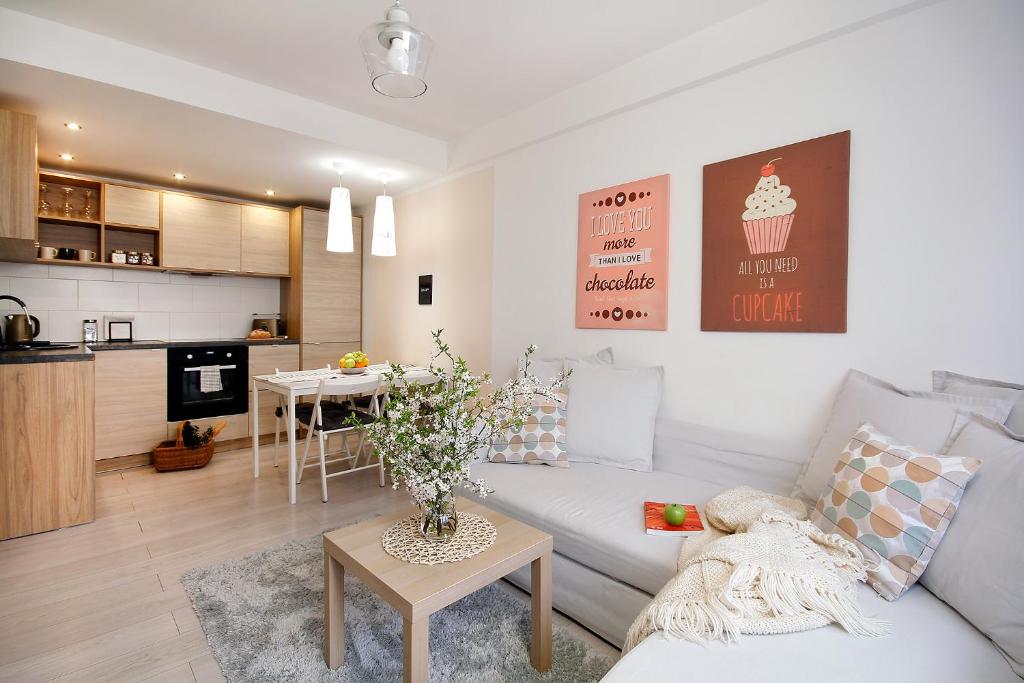 - un salon avec un canapé blanc et une table dans l'établissement W&K Apartments - Compact II, à Koszalin