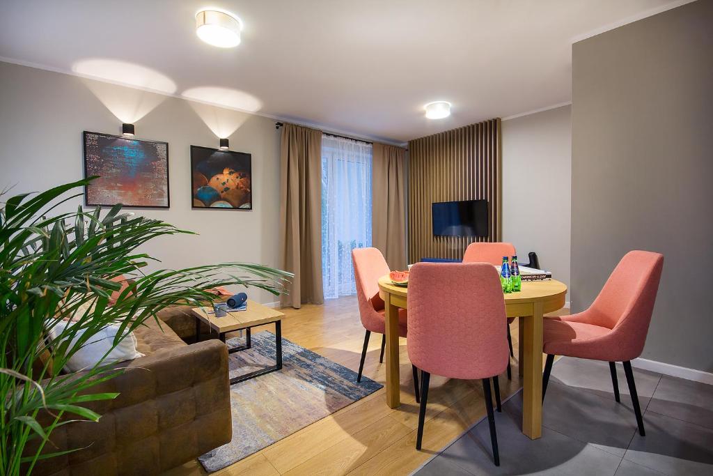 uma sala de estar com uma mesa de jantar e cadeiras em W&K Apartments - Blue Suite em Koszalin