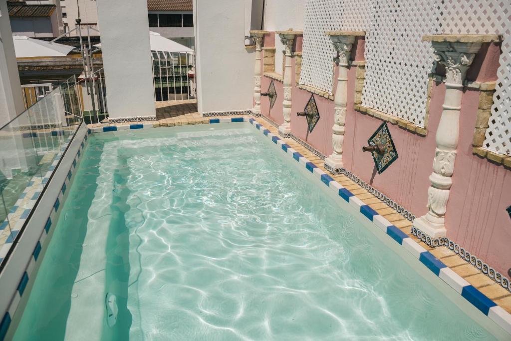 una piscina in un edificio con piscina di Apartamentos Abreu Suites a Siviglia