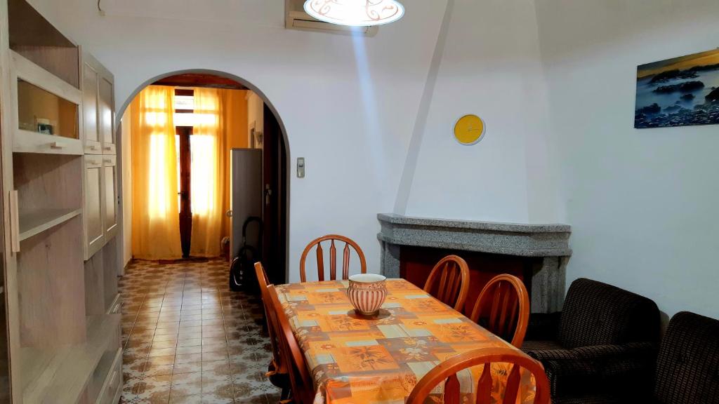 een eetkamer met een tafel met stoelen en een open haard bij Mare&Monti II in Telti