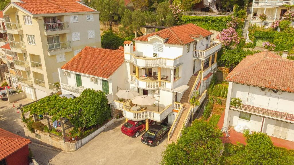 Una vista aérea de una gran casa blanca con un coche rojo. en Villa Vojnic, en Budva