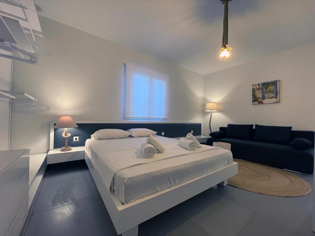 um quarto com uma cama grande e um sofá em Faskomilo Naousa Paros em Naousa
