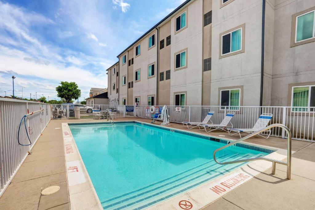 uma piscina com cadeiras e um edifício em Motel 6-Weatherford, TX em Weatherford