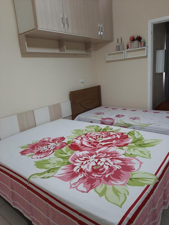 Una cama con un diseño de flores. en meu pequeno mundo, en Praia Grande
