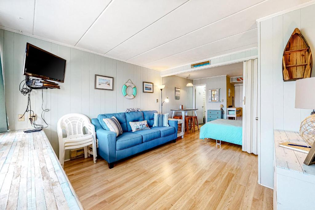 a living room with a blue couch and a bedroom at Three Cheers in Ocean City