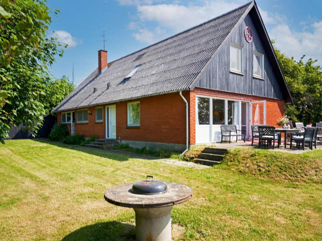 une maison avec un bain d'oiseaux devant elle dans l'établissement 12 person holiday home in Aakirkeby, à Åkirkeby