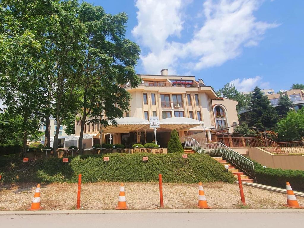 un bâtiment avec des cônes orange devant lui dans l'établissement Family hotel Classic, à Varna